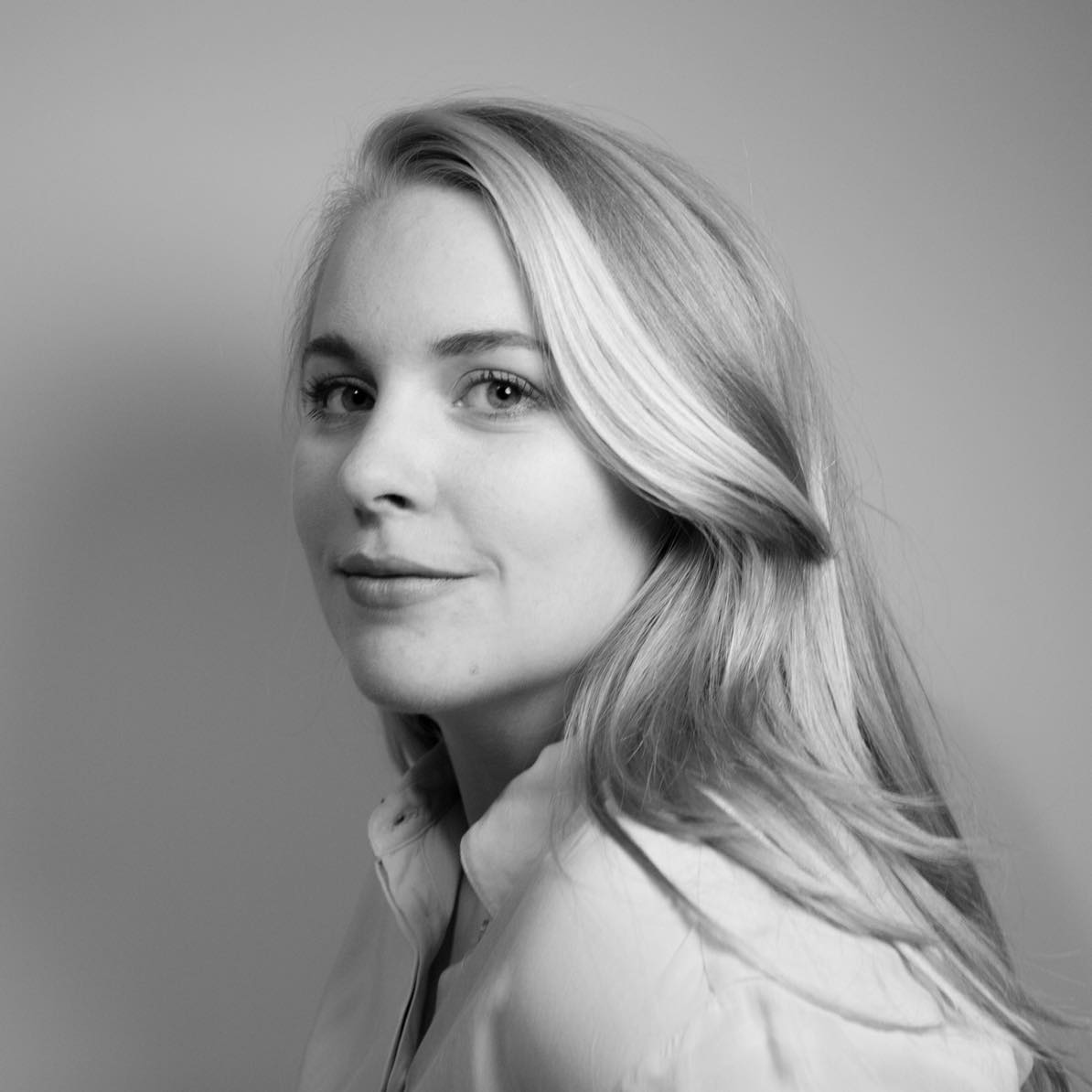 Czarno-białe zdjęcie portretowe kobiety z długimi jasnymi włosami.