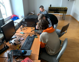 Wolontariusze naprawiający komputery w pracowni.