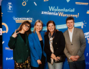 Zdjęcie przedstawia Małgorzatę Szumowską, Agnieszkę Kołodziejską, Katarzynę Dowbor, Michała Senka. W tle znajduje się niebieska plansza z napisem Wolontariat zmienia Warszawę